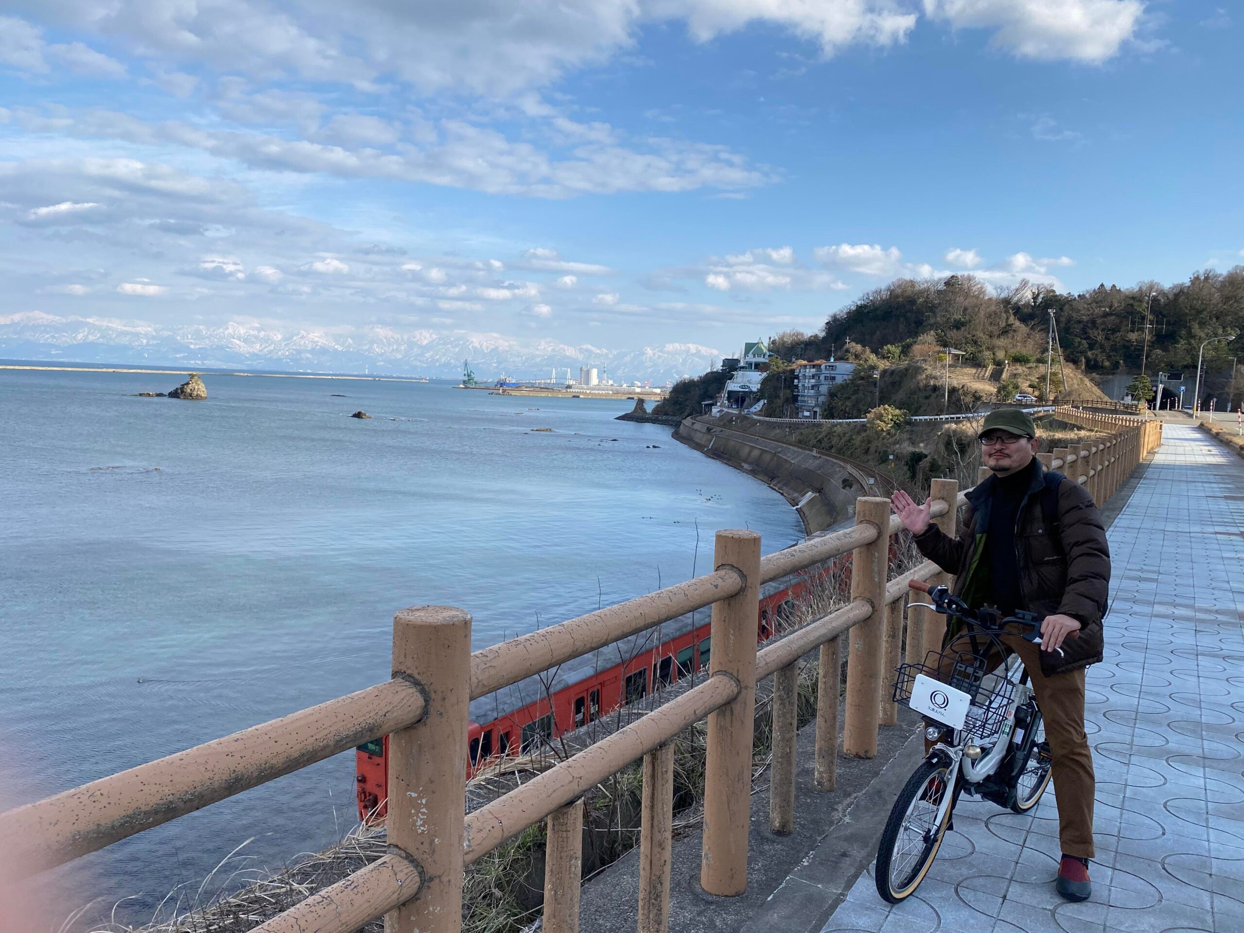 雨晴海岸の前でポーズをとる男性